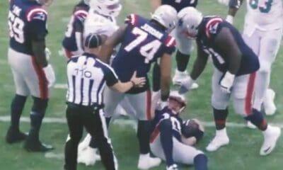 New England Patriots offensive guard Michael Jordan helps up quarterback Drake Maye following a sack.